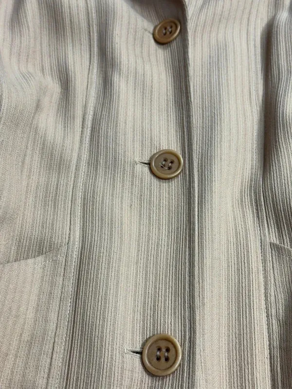 Superbe manteau fin / manteau-robe vintage de la maison Kenzo Paris. Coupe très élégante à la taille, tissu texturé à rayures verticales ton sur ton, col à revers et fermeture par trois gros boutons. Deux grandes poches plaquées sur le devant. Fabrication française de très belle qualité. Matière : 53% Viscose / Rayon, 47% [seconde matière masquée sur l'étiquette, probablement laine ou coton 4