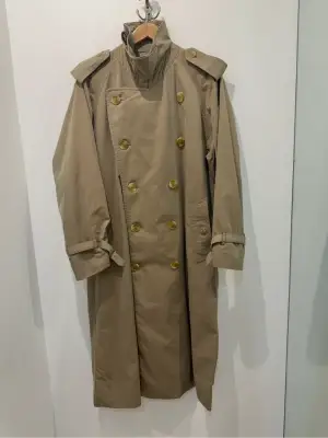 Trench-coat Burberry's beige classique à double boutonnage, col montant et doublure à carreaux emblématique.