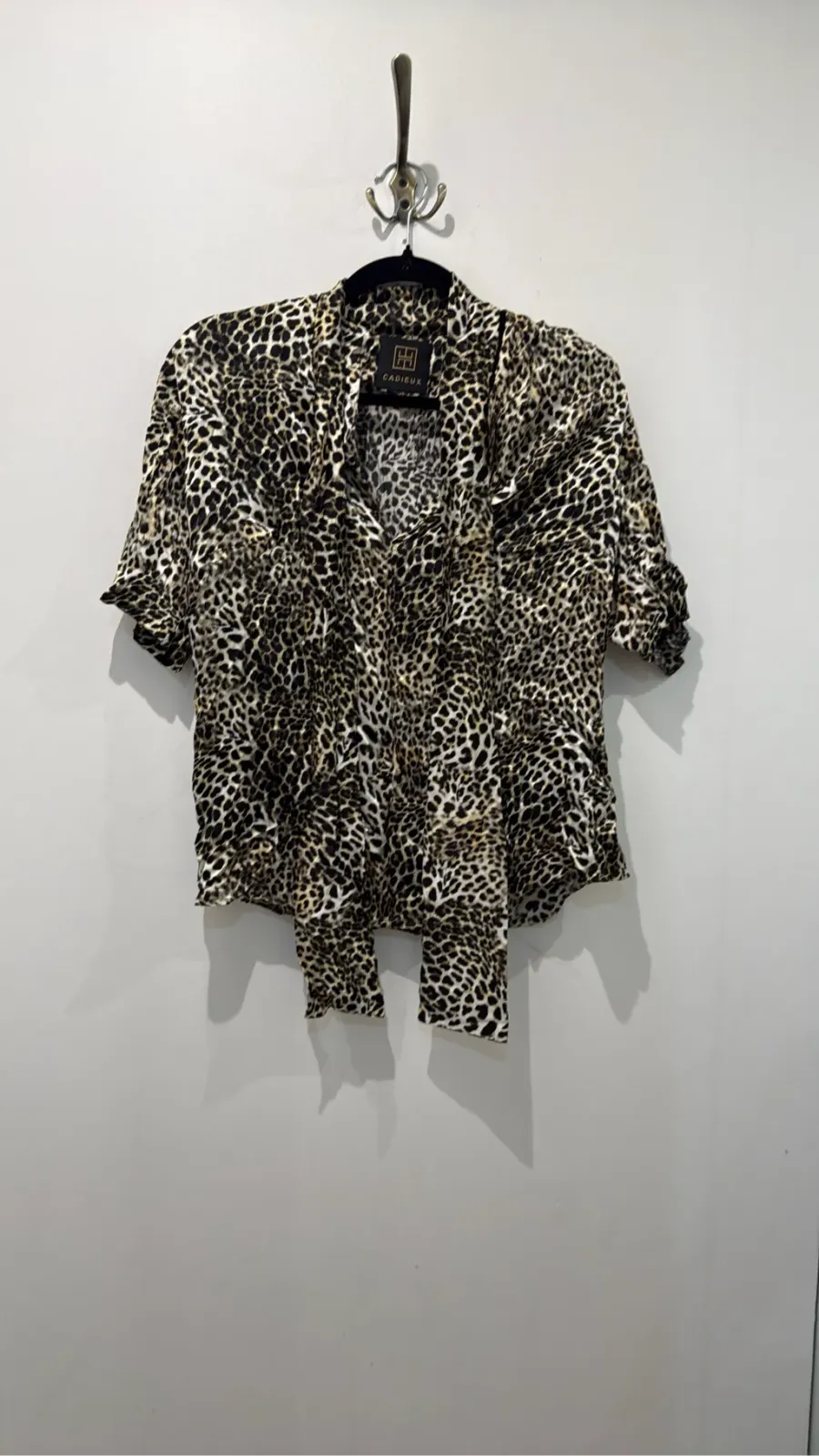 Short-sleeve leopard-print blouse with a pussy-bow collar.