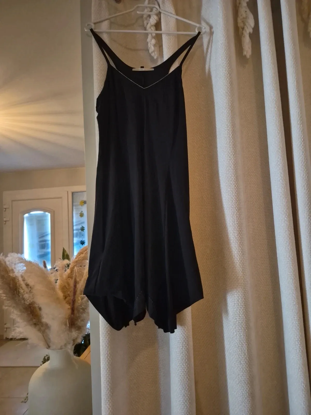 Pretty little black dress with a knitted trim at the hem. Knee-length, very light and fluid, skater style. Silver piping at the neckline and along the skirt panels. Perfect for an evening, a special day, or simply as an everyday little dress.
