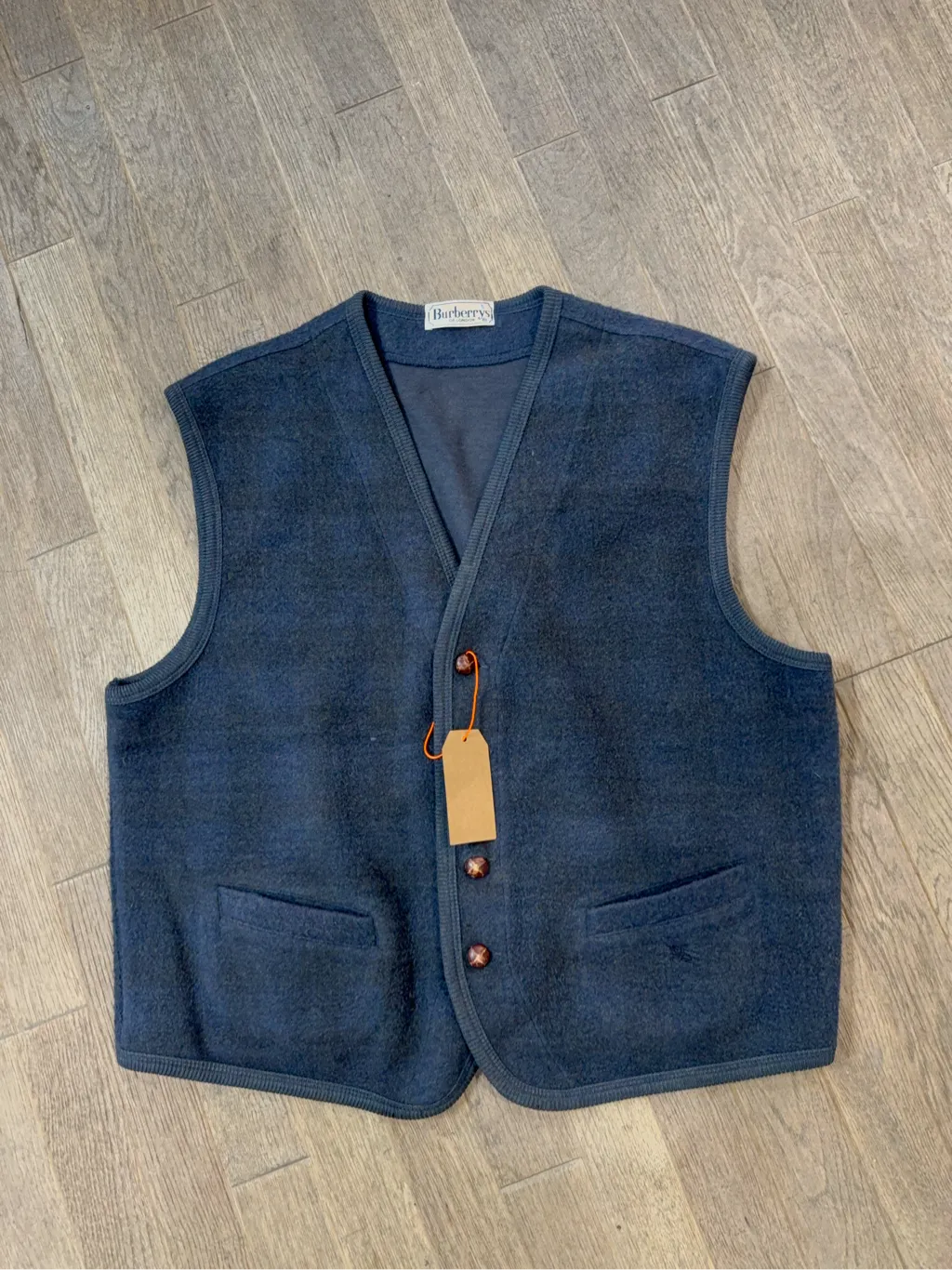 Gilet sans manches vintage en laine bleu marine de la marque Burberry's, avec des boutons décoratifs.