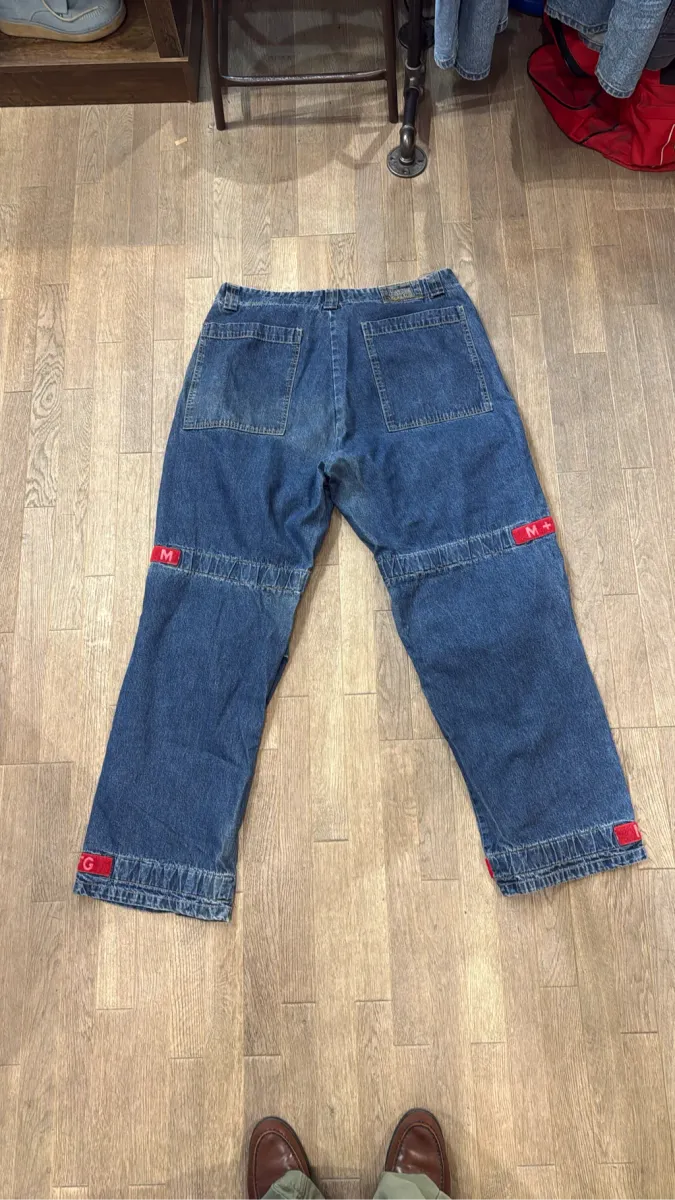 Jean cargo en denim bleu de Marithé & François Girbaud avec des sangles rouges logotées. 5