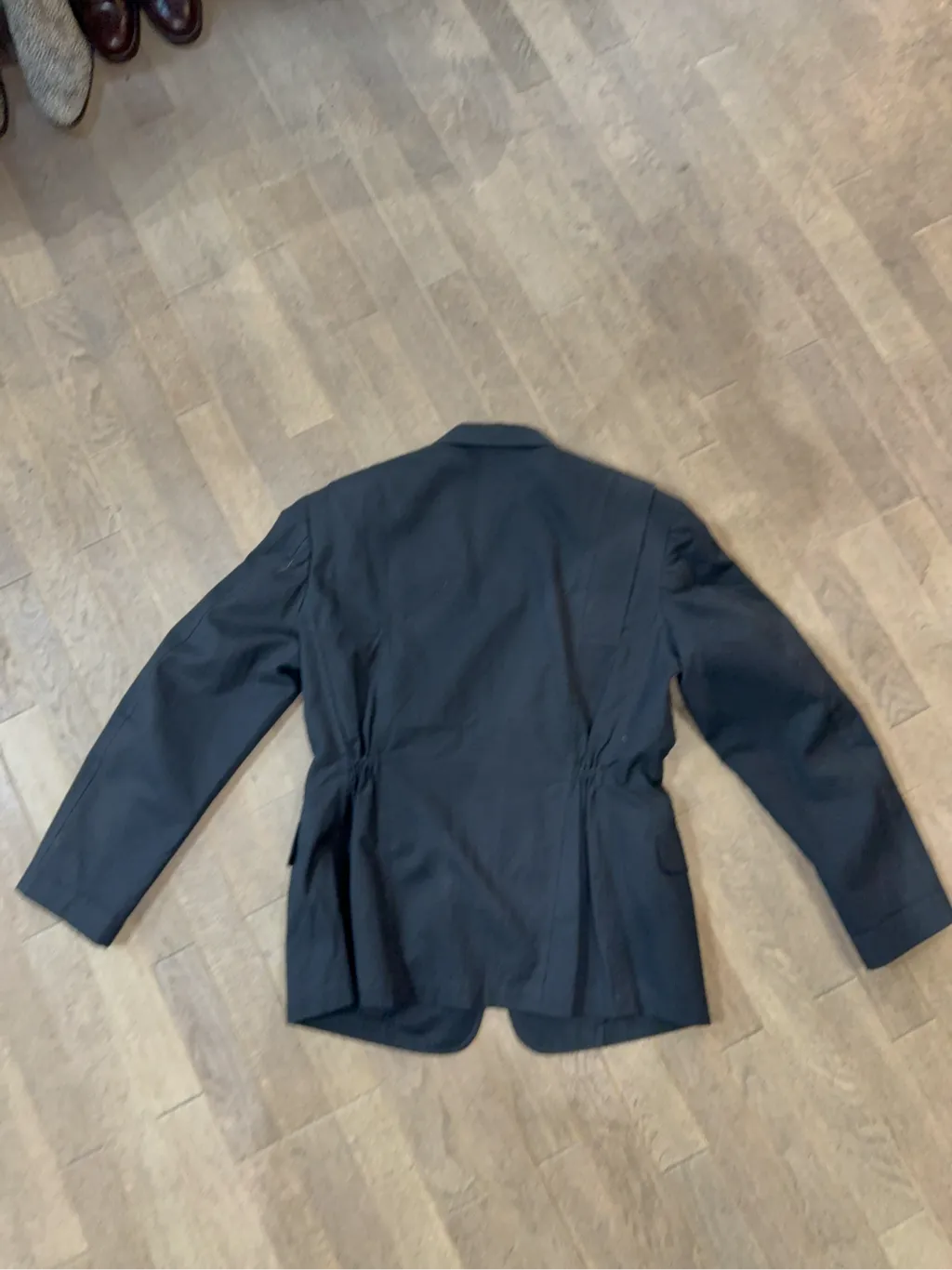 Blazer noir en coton avec fermeture à deux boutons et détail de cordon de serrage à l'arrière. 2