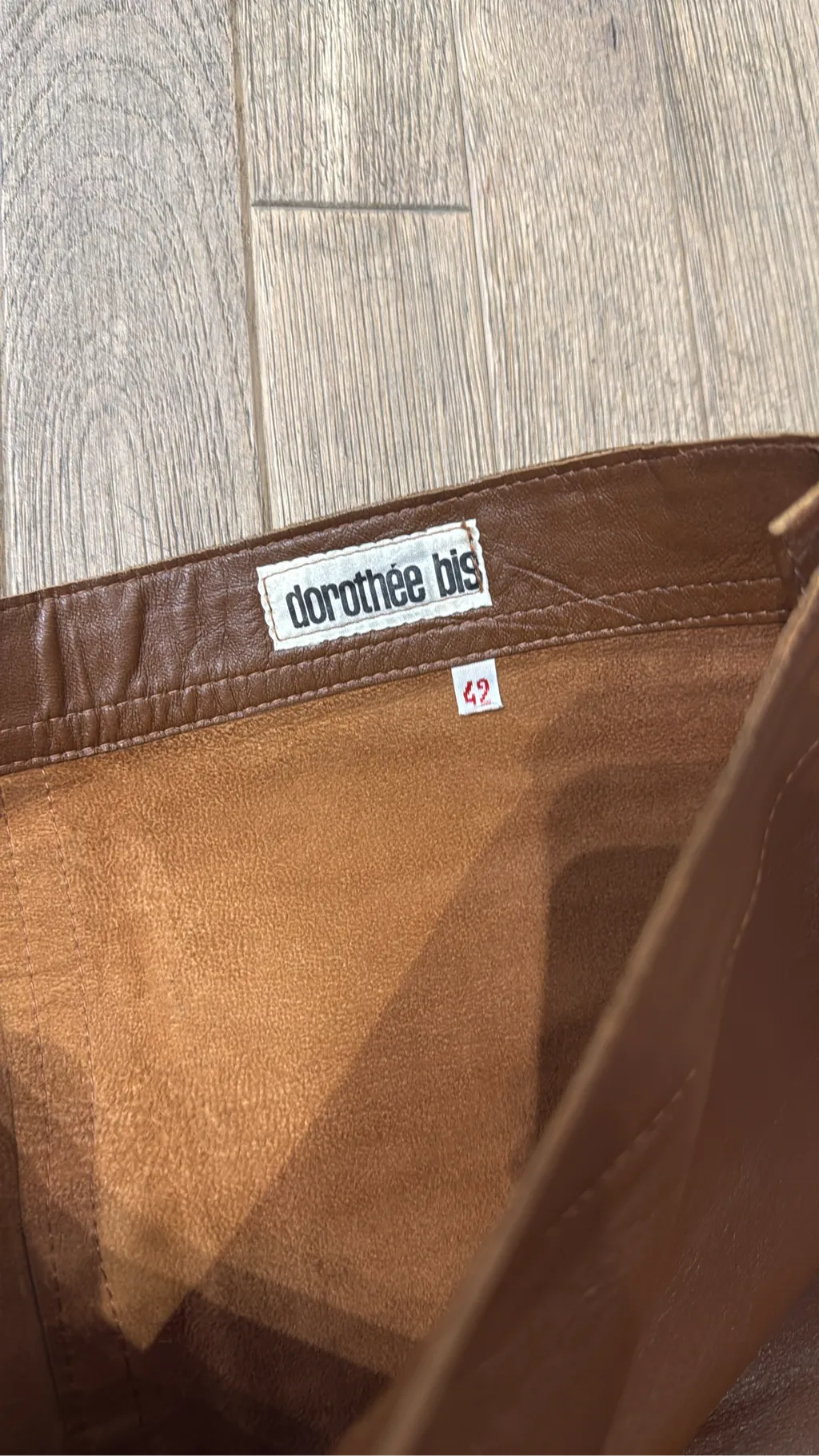 Mini-jupe en cuir marron avec une poche plaquée et des boutons décoratifs sur le côté. 3