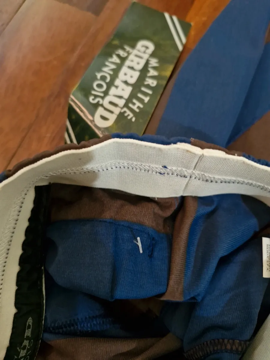 Bermuda Marithè & Francois Girbaud taille 44. Neufs avec étiquette. Fabriqués en Italie à la fin des années 80 dans un tissu polyester fin et particulier, typique de la maison. Ils présentent une ligne souple sur la cuisse qui se resserre vers le bas. Créativité stylistique et savoir-faire en matière de design fusionnent dans cette pièce iconique qui transcende le temps. Comme le montrent les photos, les bermudas sont NEUFS avec un sceau plastifié sur l'étiquette, ce qui en fait une véritable rareté. Destinés aux collectionneurs, aux amateurs de la marque et à quiconque désire une pièce au charme vintage et au goût contemporain.
Taille très petit.
Ceinture élastiquée.
Poches arrière passepoilées.
Tissu 100% polyester.
Fabriqué en Italie. 6