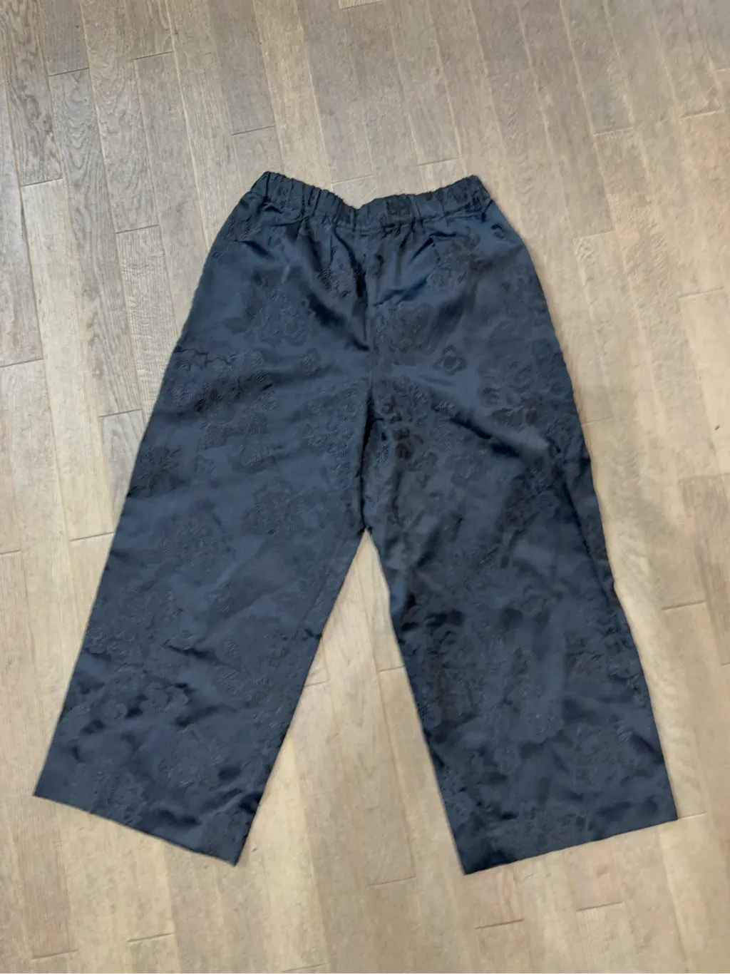 Pantalon large noir Comme des Garçons en jacquard floral avec taille élastique.