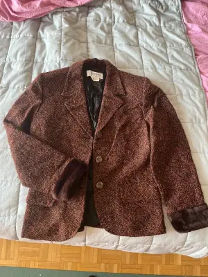Blazer Yves Saint Laurent en marron et bordeaux, pièce vintage de la maison de couture parisienne. Très bon état. Taille L (40).
