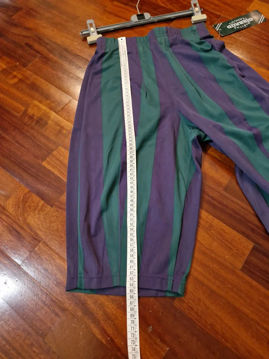 Marithè & Francois Girbaud Bermuda shorts, size 44. New with tags. Made in Italy in the late 80s from a fine and unique polyester fabric, typical of the brand. They feature a loose fit on the thigh that tapers towards the bottom. Stylistic creativity and design skill merge in this iconic piece that transcends time. As shown in the photos, the Bermuda shorts are NEW with a plastic seal on the tag, making them a true rarity. Intended for collectors, brand enthusiasts, and anyone desiring a piece with vintage charm and contemporary appeal.
Run very small.
Elasticated waistband.
Welt back pockets.
100% polyester fabric.
Made in Italy. 10