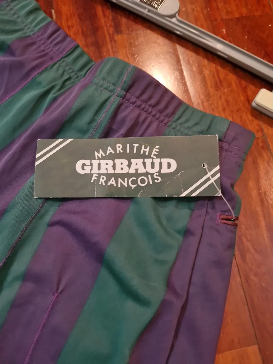 Marithè & Francois Girbaud Bermuda shorts, size 44. New with tags. Made in Italy in the late 80s from a fine and unique polyester fabric, typical of the brand. They feature a loose fit on the thigh that tapers towards the bottom. Stylistic creativity and design skill merge in this iconic piece that transcends time. As shown in the photos, the Bermuda shorts are NEW with a plastic seal on the tag, making them a true rarity. Intended for collectors, brand enthusiasts, and anyone desiring a piece with vintage charm and contemporary appeal.
Run very small.
Elasticated waistband.
Welt back pockets.
100% polyester fabric.
Made in Italy. 2