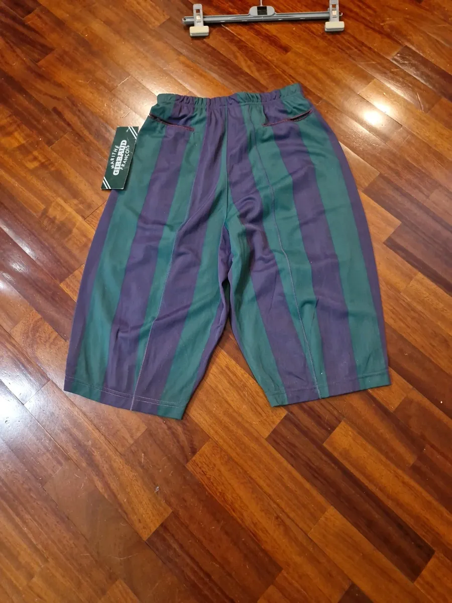 Marithè & Francois Girbaud Bermuda shorts, size 44. New with tags. Made in Italy in the late 80s from a fine and unique polyester fabric, typical of the brand. They feature a loose fit on the thigh that tapers towards the bottom. Stylistic creativity and design skill merge in this iconic piece that transcends time. As shown in the photos, the Bermuda shorts are NEW with a plastic seal on the tag, making them a true rarity. Intended for collectors, brand enthusiasts, and anyone desiring a piece with vintage charm and contemporary appeal.
Run very small.
Elasticated waistband.
Welt back pockets.
100% polyester fabric.
Made in Italy. 7