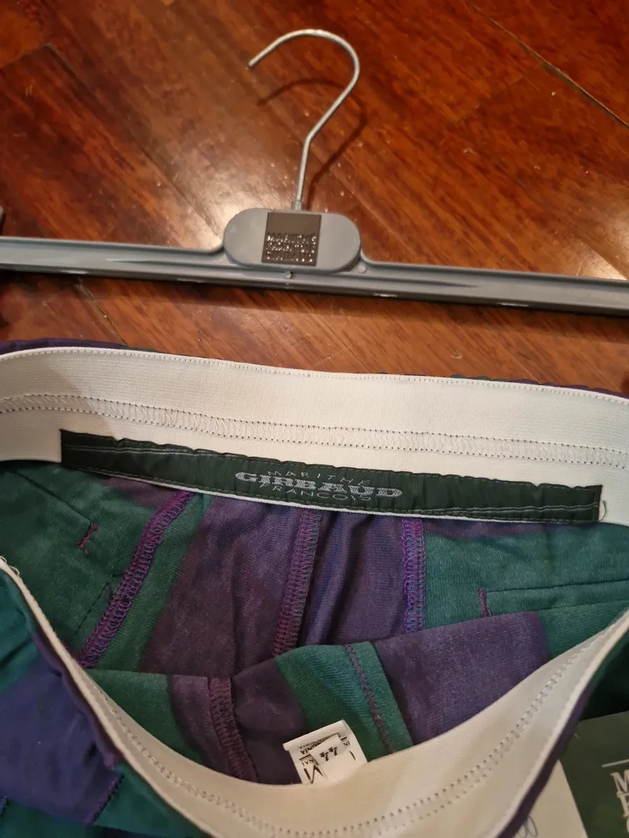 Marithè & Francois Girbaud Bermuda shorts, size 44. New with tags. Made in Italy in the late 80s from a fine and unique polyester fabric, typical of the brand. They feature a loose fit on the thigh that tapers towards the bottom. Stylistic creativity and design skill merge in this iconic piece that transcends time. As shown in the photos, the Bermuda shorts are NEW with a plastic seal on the tag, making them a true rarity. Intended for collectors, brand enthusiasts, and anyone desiring a piece with vintage charm and contemporary appeal.
Run very small.
Elasticated waistband.
Welt back pockets.
100% polyester fabric.
Made in Italy. 3