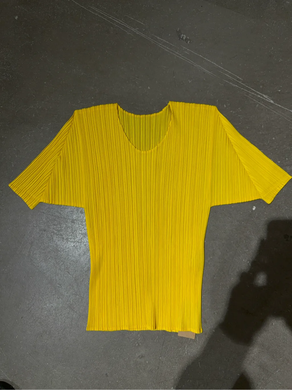 T-shirt plissé jaune à col V et manches courtes, de la ligne Pleats Please.