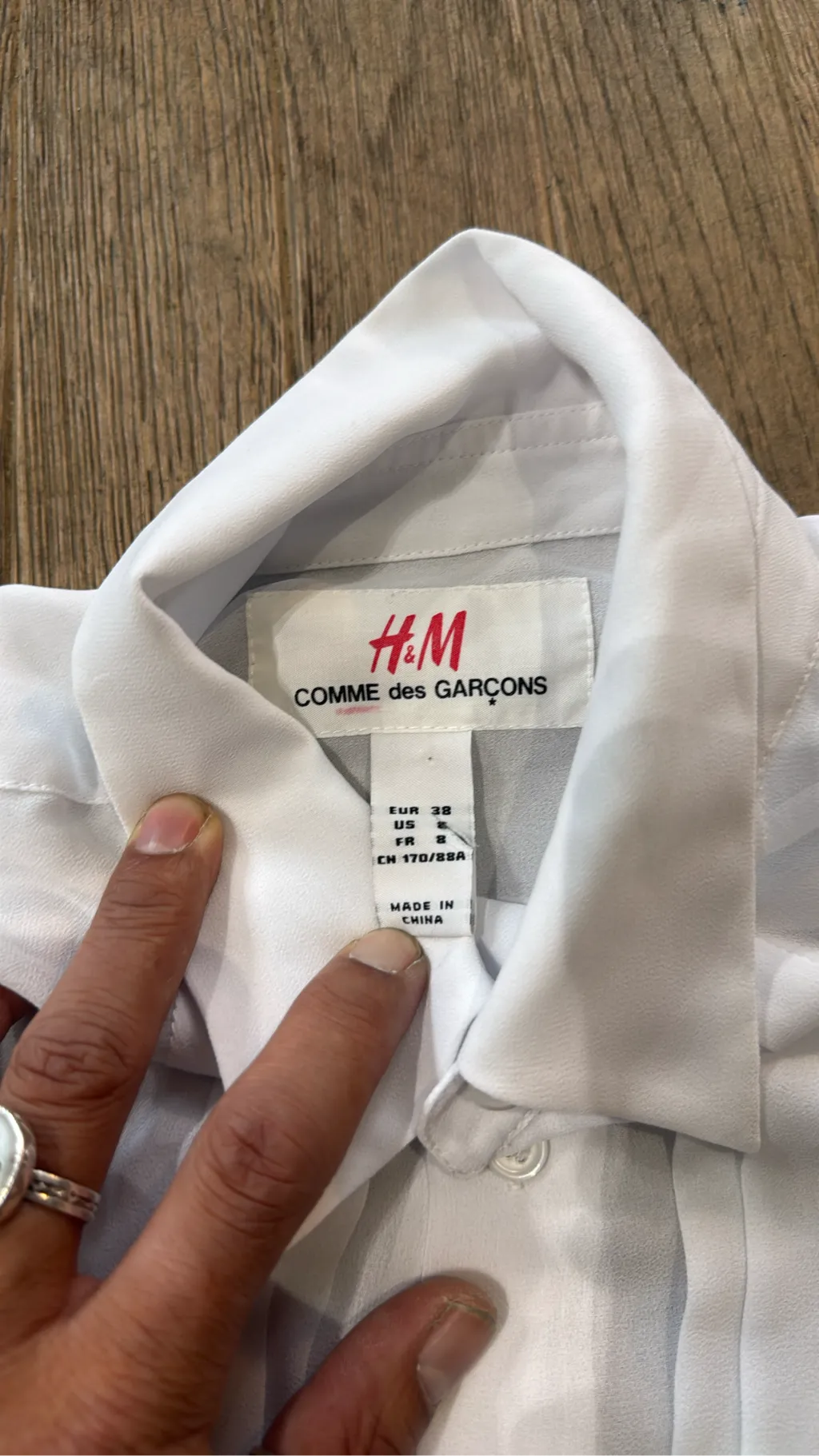 Blouse blanche transparente H&M x Comme des Garçons avec détails de plis nervurés sur le devant et poignets à volants. 3