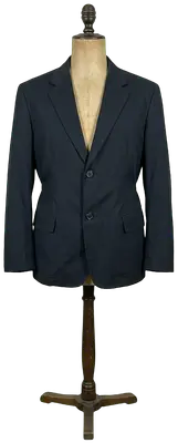 Blazer noir en coton avec fermeture à deux boutons et détail de cordon de serrage à l'arrière.